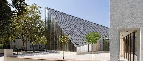 Modernes Gebäude mit schrägen Dächern und Fenstern.